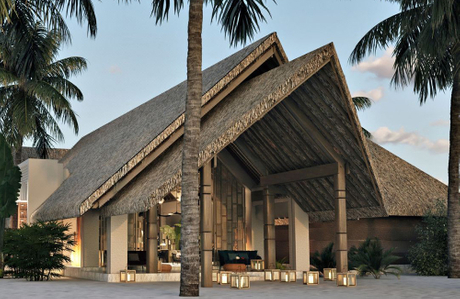 JW Marriott resort with a thatched-roof building, surrounded by palm trees and illuminated by warm lanterns at dusk..jpg