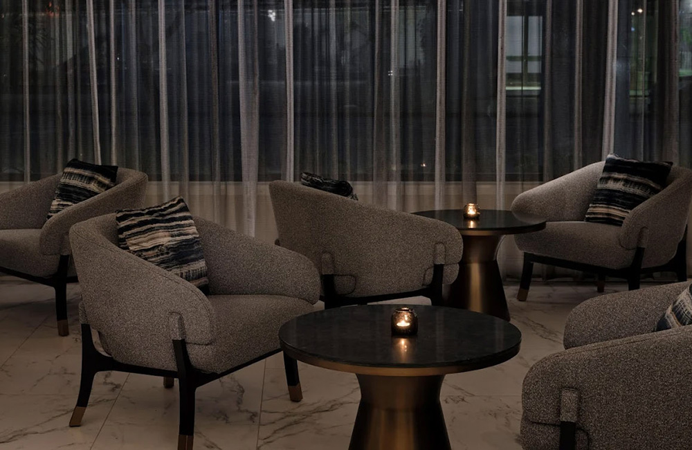 A cozy lounge area at Intercontinental with plush armchairs, patterned cushions, and ambient candlelight creating a warm atmosphere